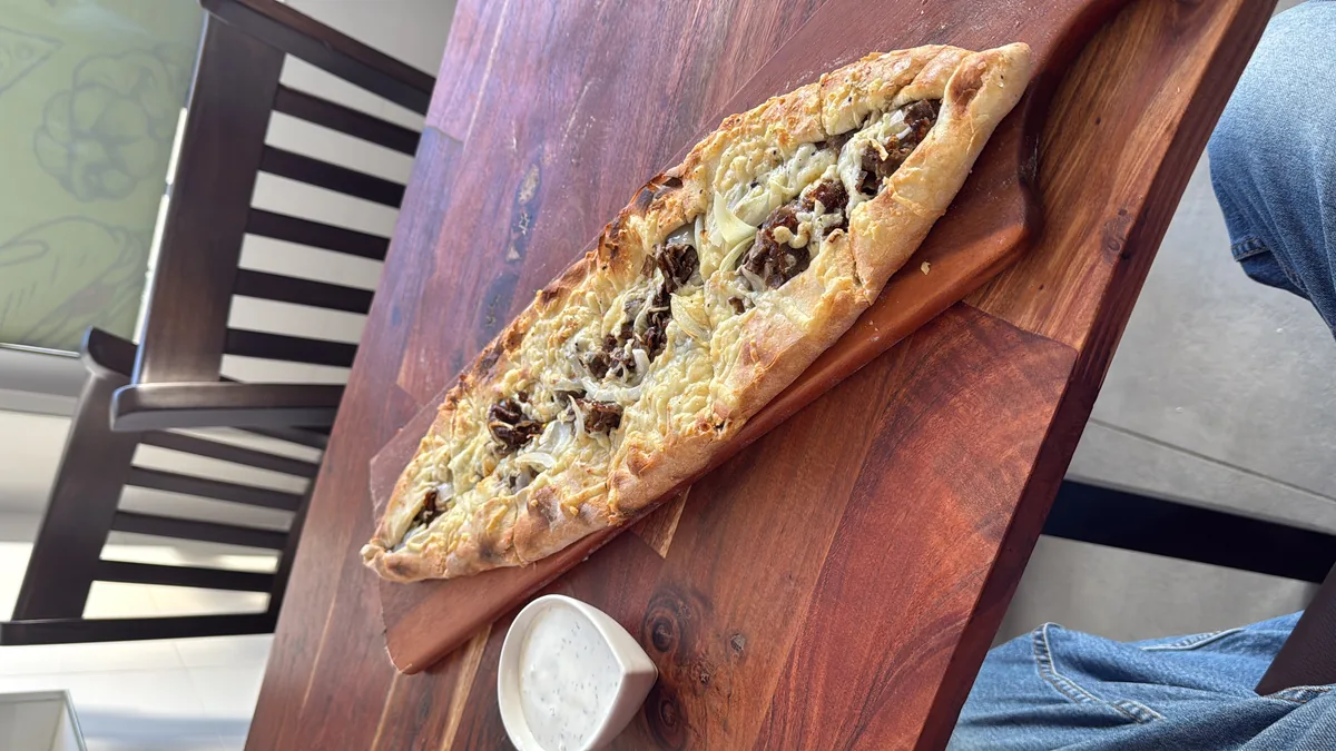 Frische Pide mit Fleisch und Käse auf Holzbrett